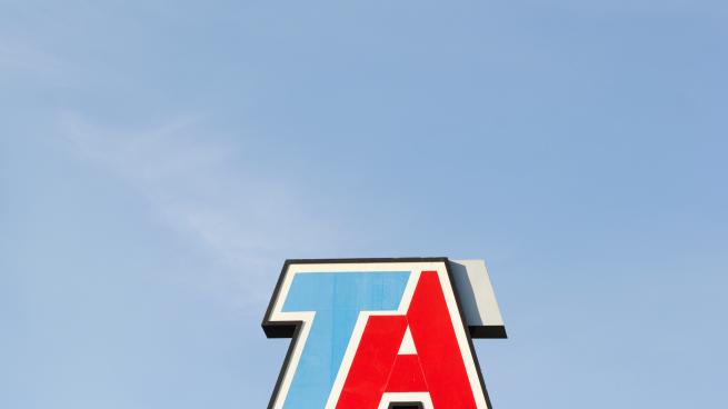 A logo for TA on top of a sign.